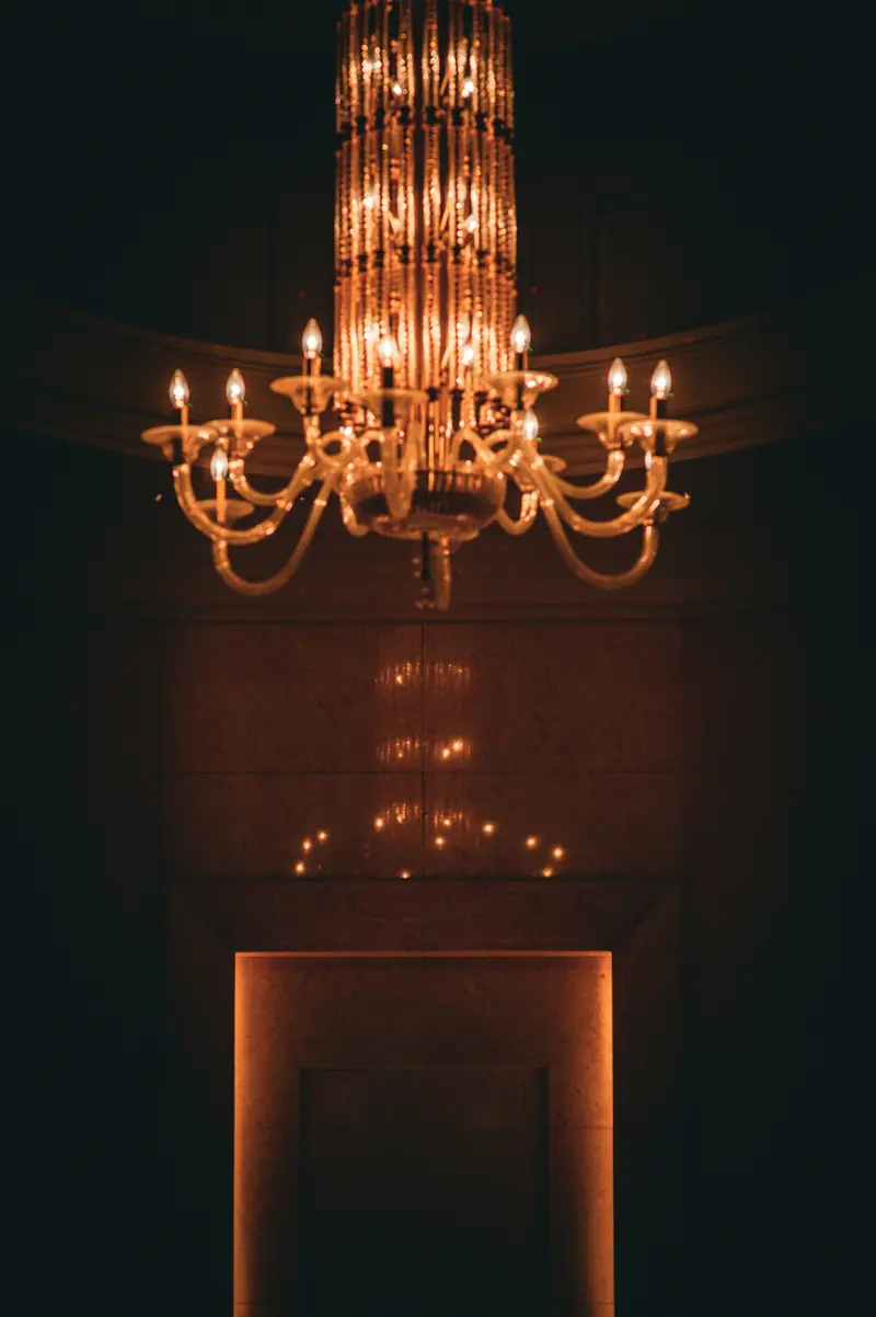 An ornate candle chandelier casting a warm glow in a darkened room