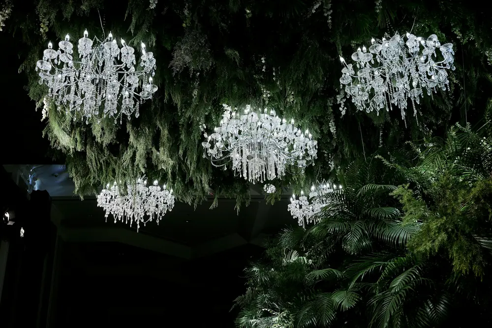 Crystal chandeliers suspended among lush hanging greenery