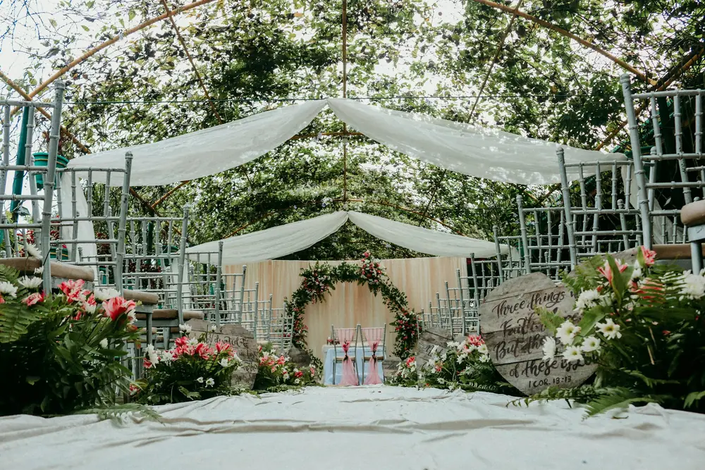 Draped canopies and floral arrangements set beneath trees