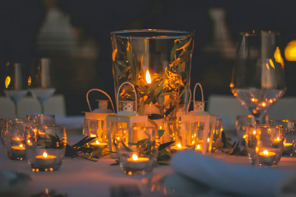 Glass lanterns and tea lights glowing on an evening reception table